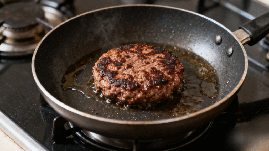 Juicy beef burger patty cooking on a hot pan, developing a golden brown crust on the surface