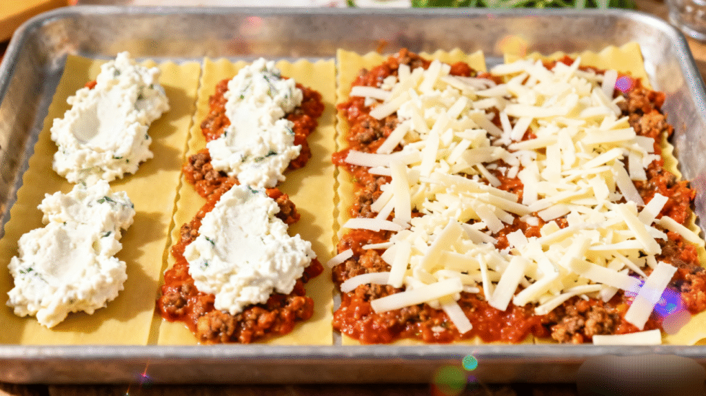 Layering lasagna noodles with meat sauce and cheese inside a baking dish before baking