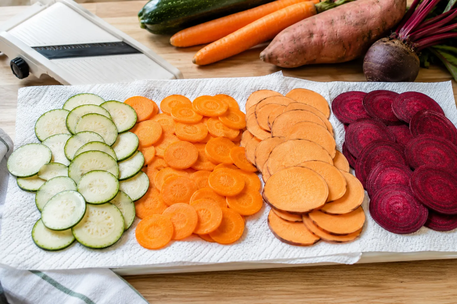 Fresh vegetable slices drying on paper towels before cooking to achieve crispy Air Fryer Veggie Chips.